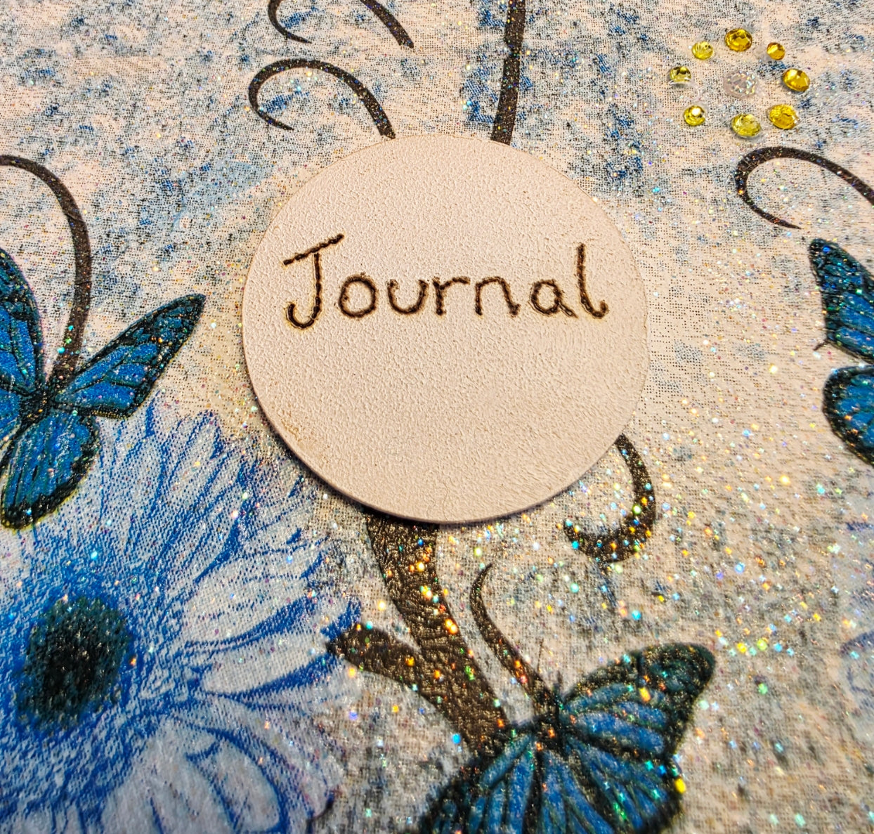 decoupage Journal with blue floral and butterfly  design and blue ribbons on a wooden surface