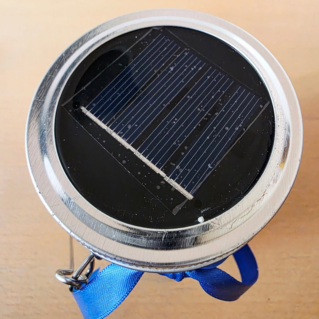 Small round device with a solar panel on a beige background