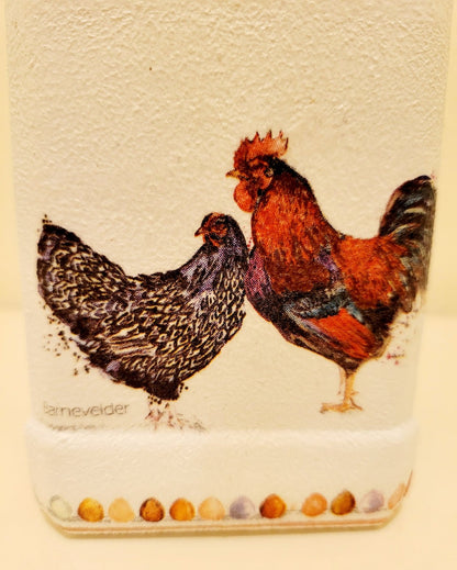 a brown and a black chicken on the side of a white painted bottle