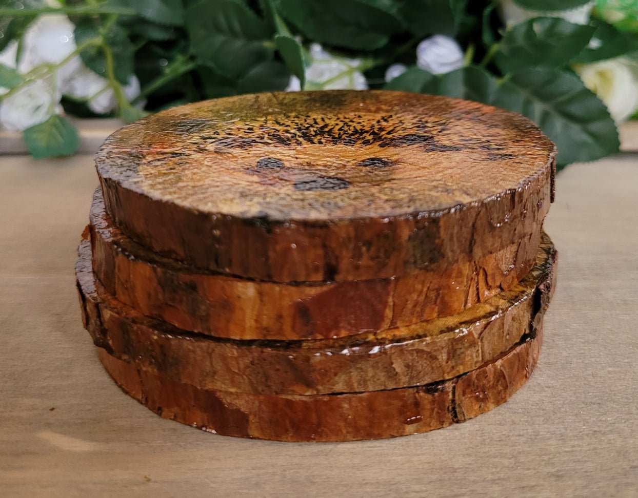 Four Decoupage Natural Wood Slice Hedgehog coasters. Varnished glossy look, hedgehog detail and bark left on the outer edge. Stacked on top of one another