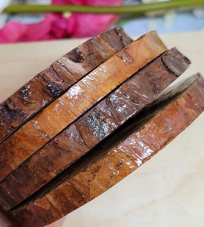 four plain wood slice coasters with bark left on