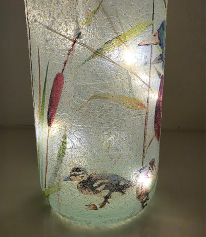 duckling decoupaged onto the bottom of a lit up wine bottle