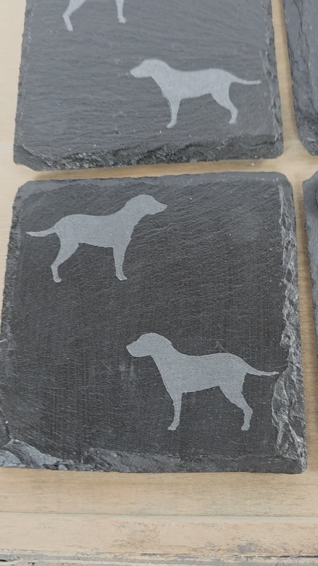Four black slate coasters each with two labrador etched images on - dogs facing eachother