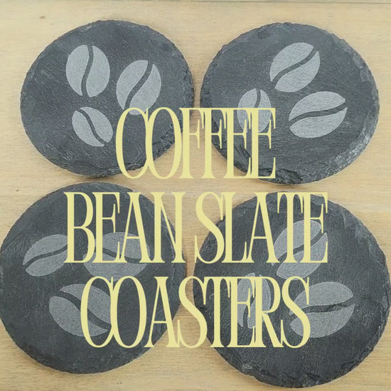 video of four black round slate coasters with coffee bean design