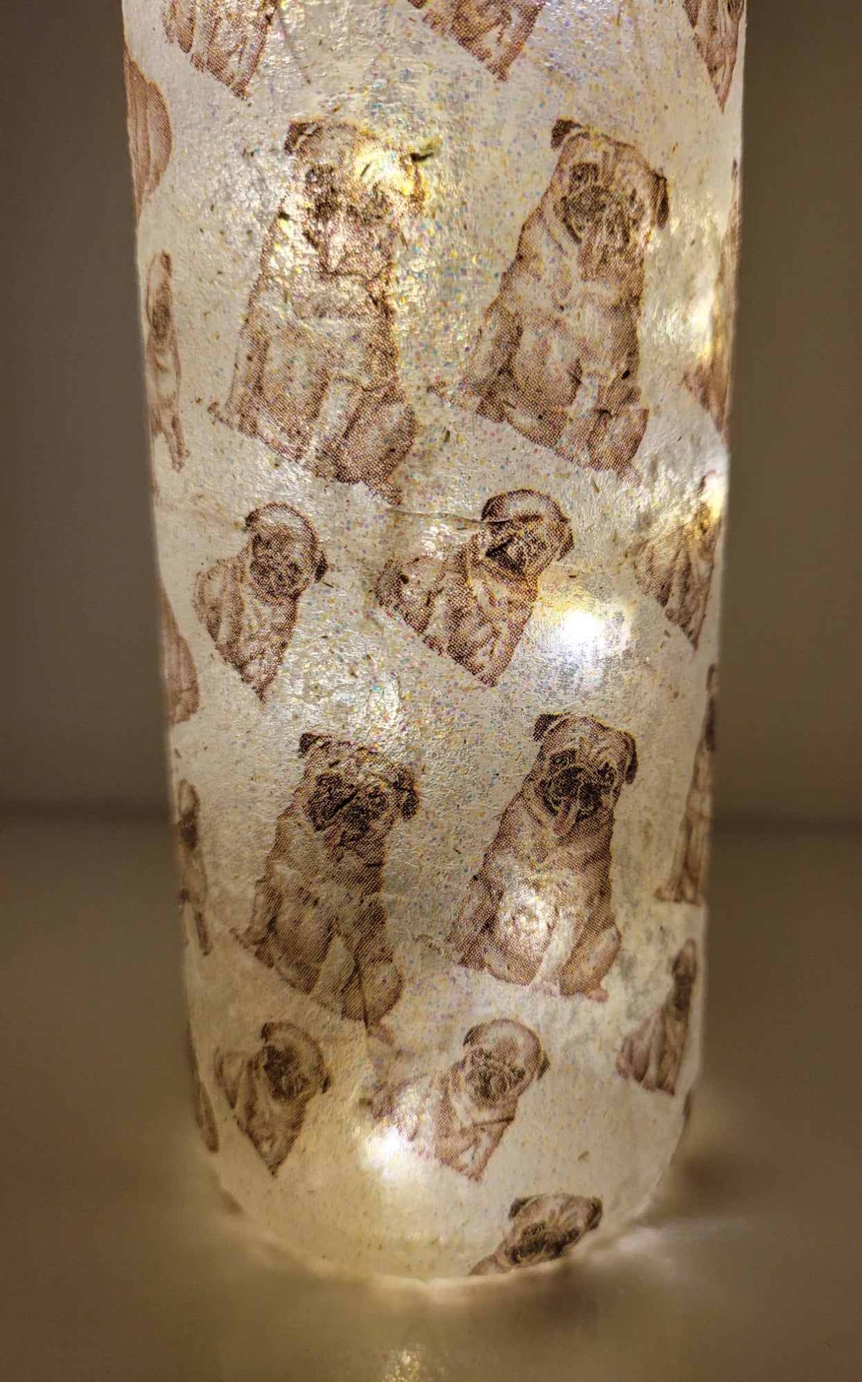 wine bottle decorated with tiny pug dog images. Lit up 