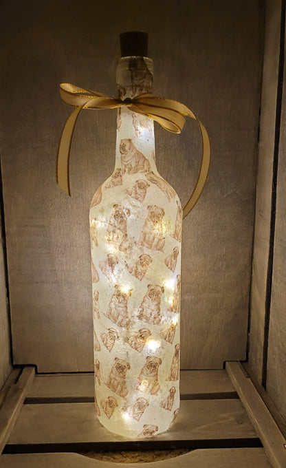 wine bottle decorated with tiny pug dog images. Cork LED lights and gold ribbon embellishment