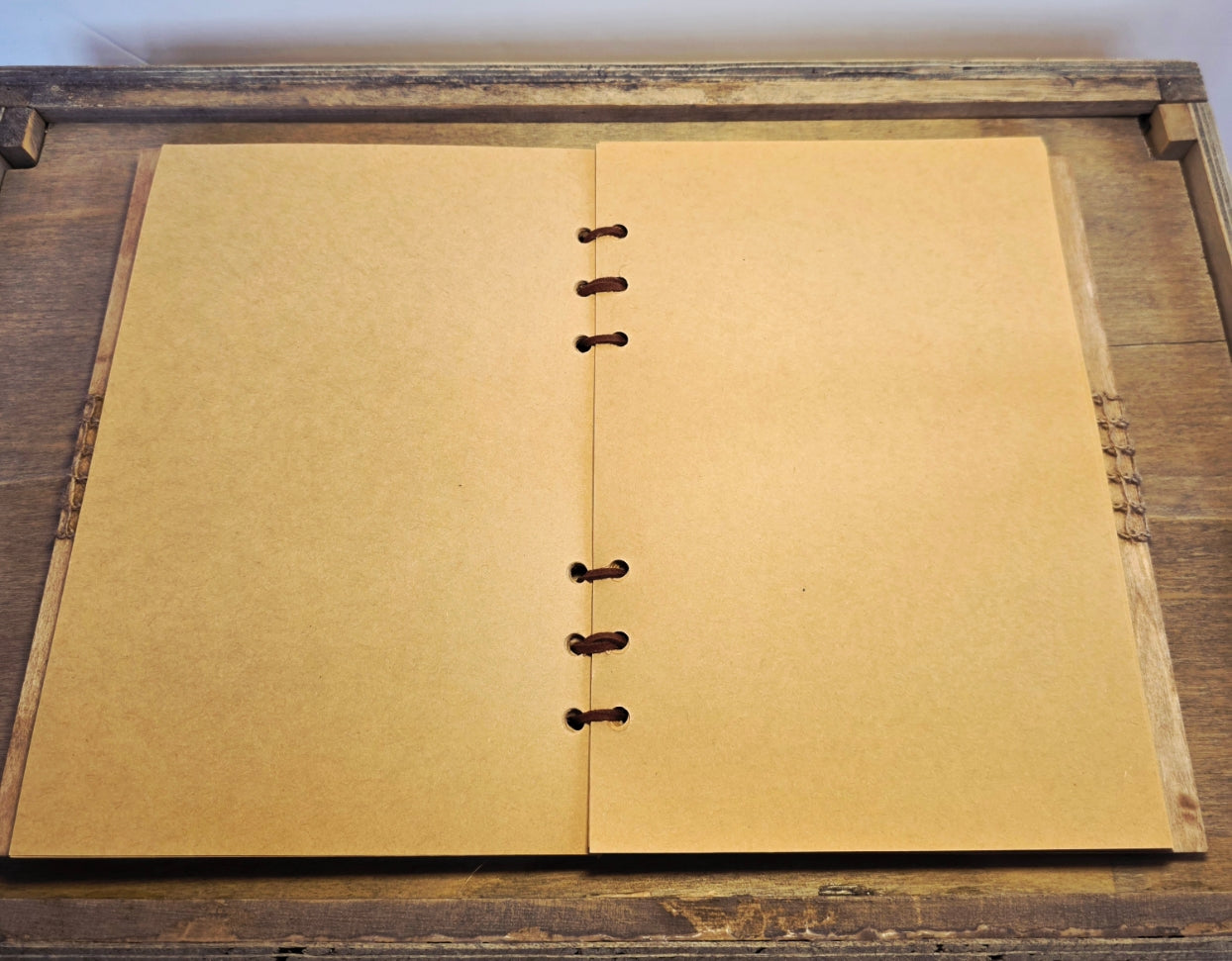 Open notebook with beige pages on a wooden surface