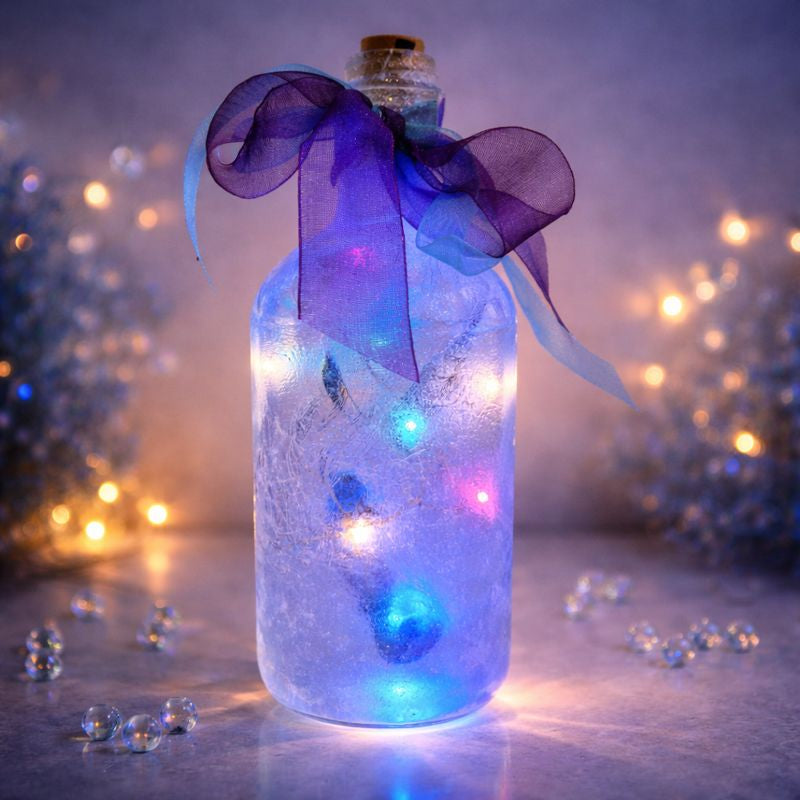 Decorative bottle with unicorn design LED lights and a purple ribbon against a blurred festive background
