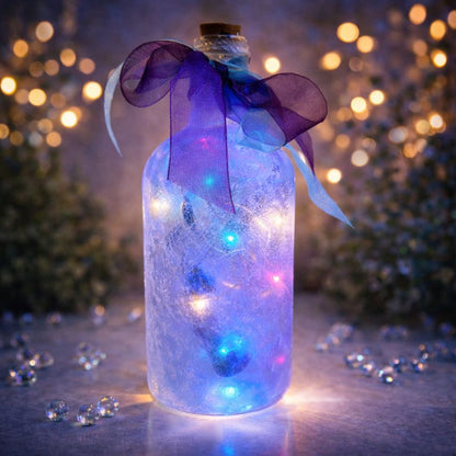 Decorative bottle with unicorn design LED lights and a purple ribbon against a blurred festive background