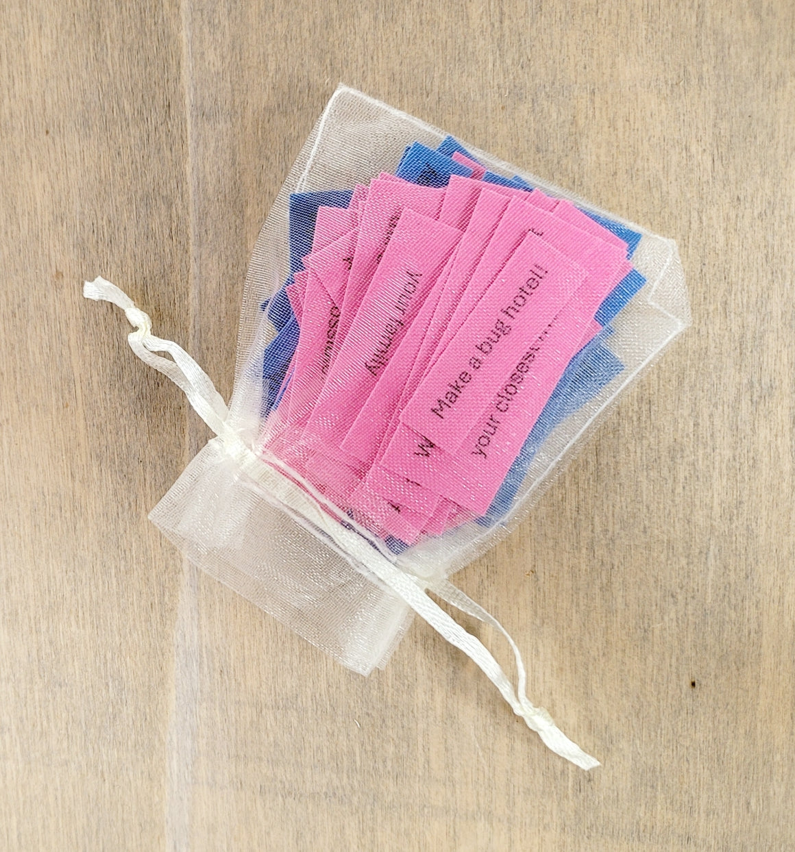 pale organza bag with pink and blue pieces of card inside with quotes on them
