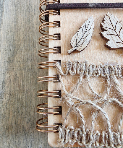 Wooden journal with decorative wooden leaf elements. Burlap jute decoration top and bottom. Faux suede tie
