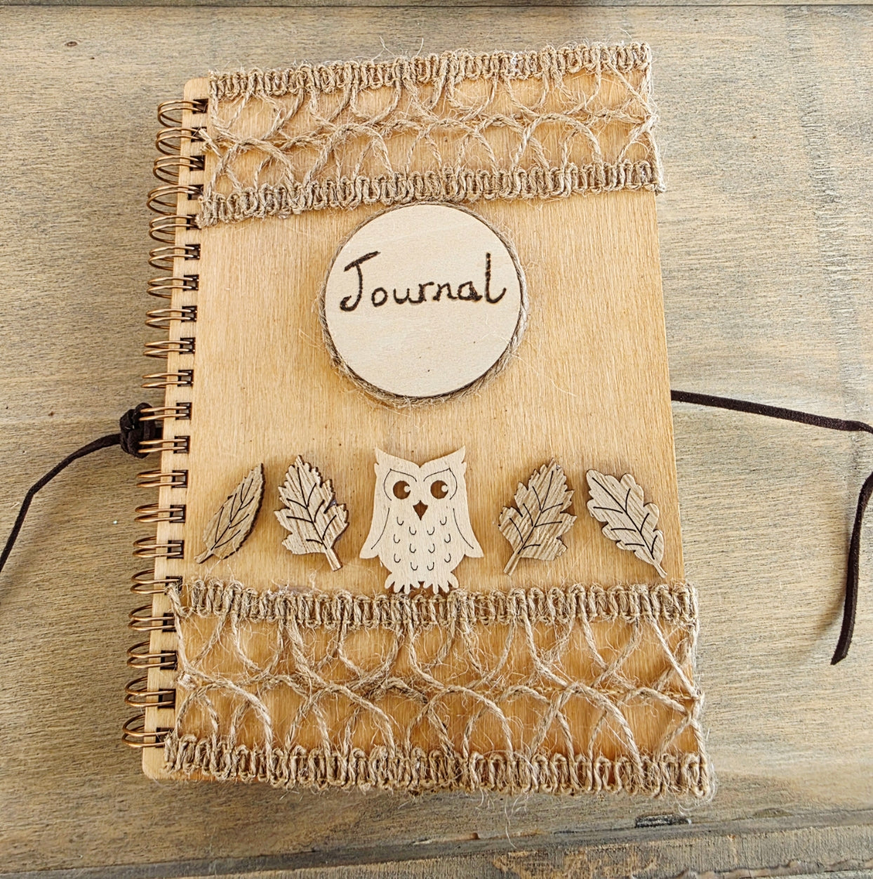 Wooden journal with decorative wooden leaves and owl elements. Burlap jute decoration top and bottom. Faux suede tie