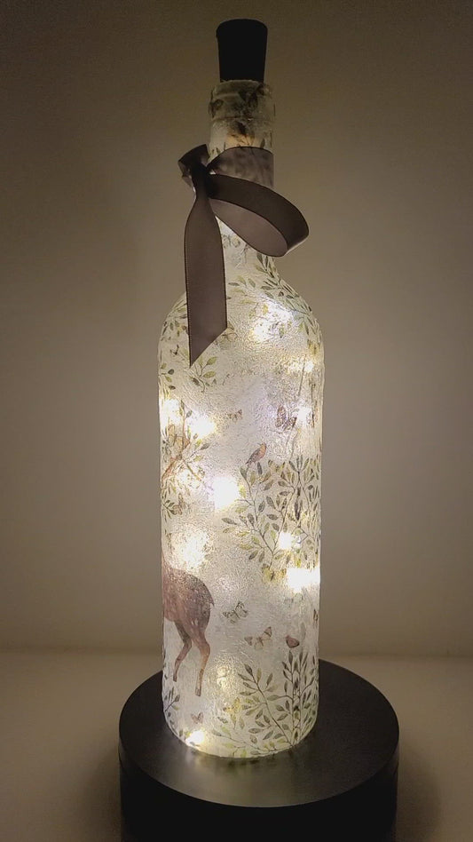Rotating lit up wine bottle with Stag and leaf detail. Grey bow finish