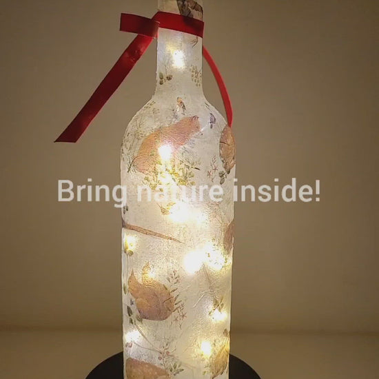 Rotating example of a Lit up wine bottle with wild animal detail. Red Bow